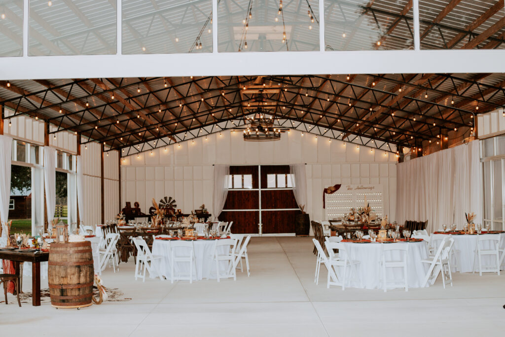 Big Wedding Barn Pavilion offers the best of both worlds.  White with wood accents and clear glass wedding barn. Tables are set and ready for  wedding guests after an outdoor ceremony.  